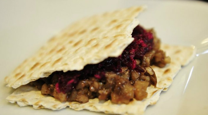 Closeup of a Hillel sandwich of charoset and maror between two pieces of matzah 